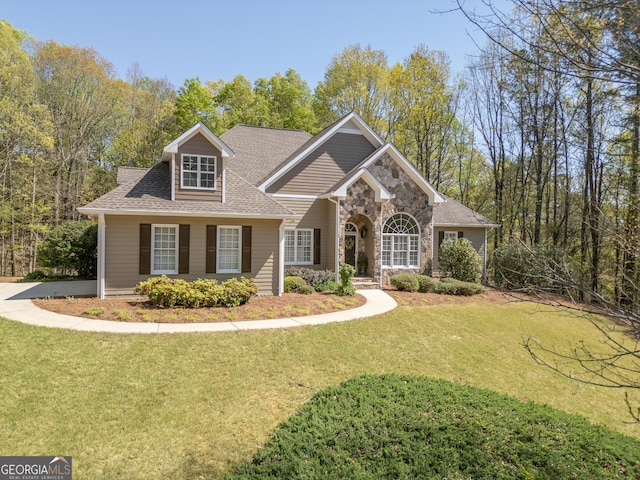 craftsman house with a front lawn, stone siding, and a shingled roof