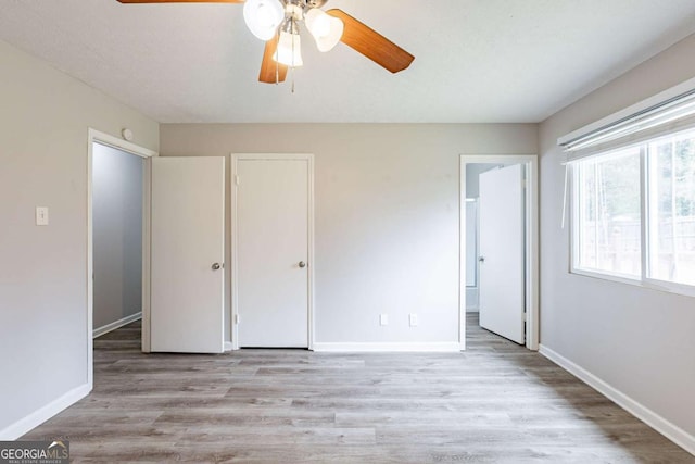 unfurnished bedroom featuring baseboards, a ceiling fan, and wood finished floors