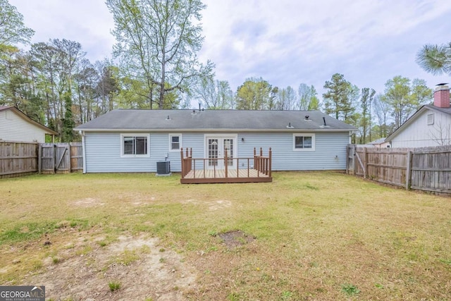 rear view of property with central air condition unit, a yard, a fenced backyard, french doors, and a deck