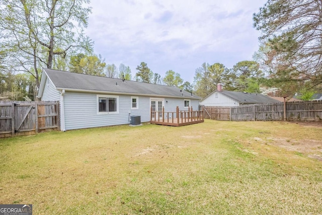 rear view of property with a yard, a fenced backyard, and a deck