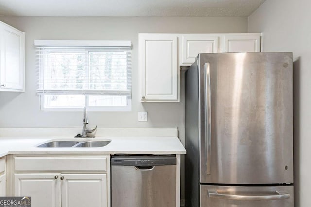 kitchen featuring a sink, light countertops, appliances with stainless steel finishes, and white cabinetry