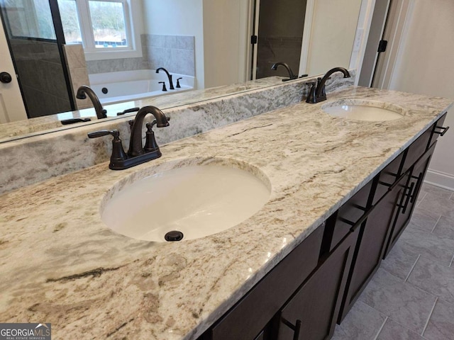 full bathroom featuring double vanity, a sink, baseboards, and a bath