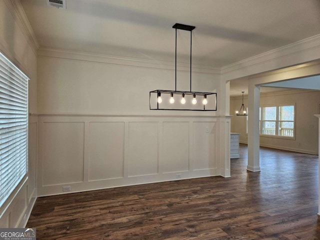 unfurnished dining area with crown molding, a decorative wall, and dark wood-style flooring