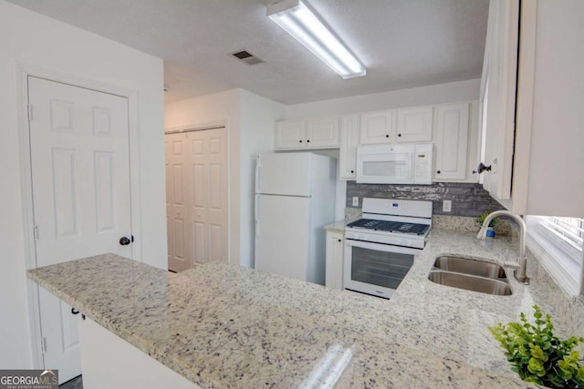 102 Manley Ct, Woodstock, GA 30188 - kitchen with white appliances, a sink, white cabinets, a peninsula, and light stone counters