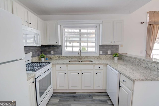 102 Manley Ct, Woodstock, GA 30188 - kitchen featuring white appliances, a sink, white cabinets, light wood-type flooring, and a peninsula
