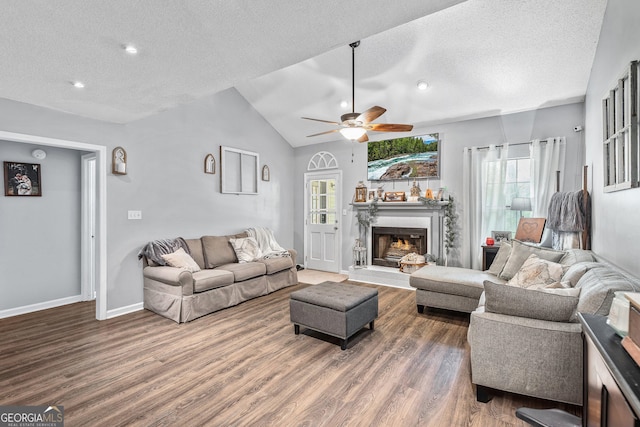 95 Joshua Ct, Zebulon, GA 30295 - living room with a textured ceiling, wood finished floors, ceiling fan, lofted ceiling, and a lit fireplace