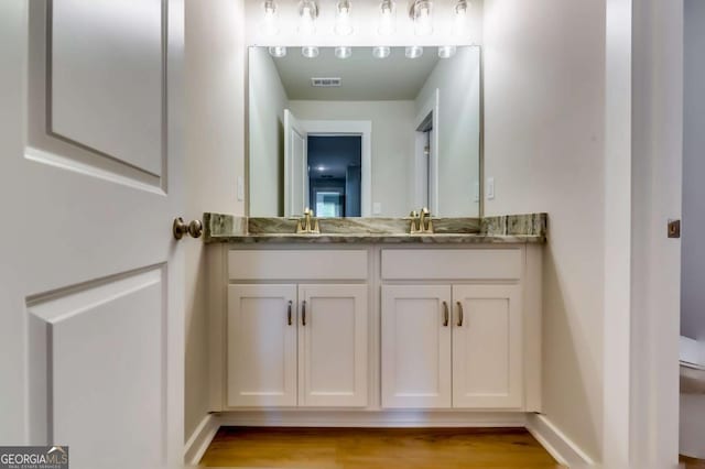 497 Principal Meridian Dr, Dallas, GA 30132 - bathroom with double vanity, toilet, wood finished floors, and baseboards