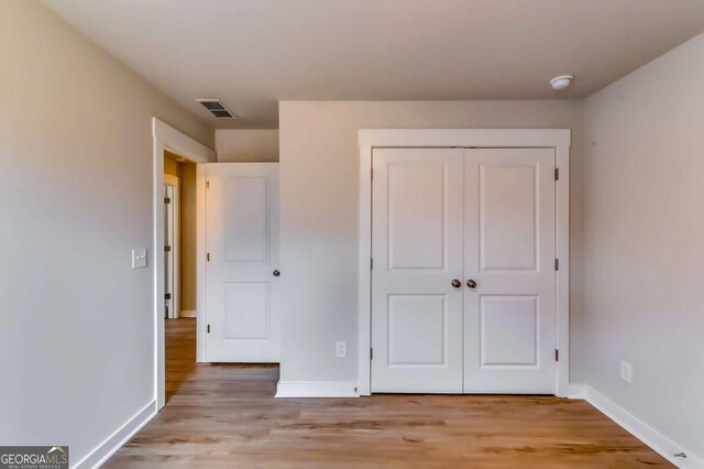 497 Principal Meridian Dr, Dallas, GA 30132 - unfurnished bedroom featuring light wood-style flooring, baseboards, and a closet