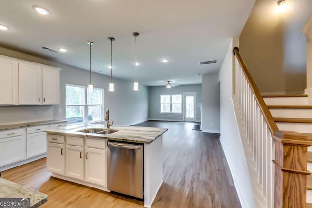 497 Principal Meridian Dr, Dallas, GA 30132 - kitchen featuring stainless steel dishwasher, a sink, light wood-style floors, hanging light fixtures, and white cabinetry
