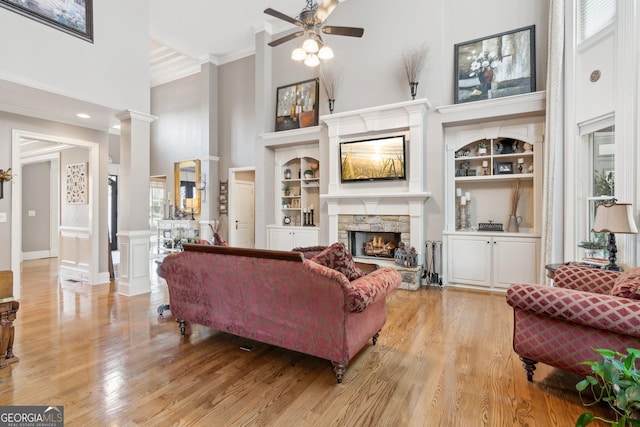 968 Woodtrace Ln, Auburn, GA 30011 - living room featuring a fireplace, light wood finished floors, a towering ceiling, and a ceiling fan