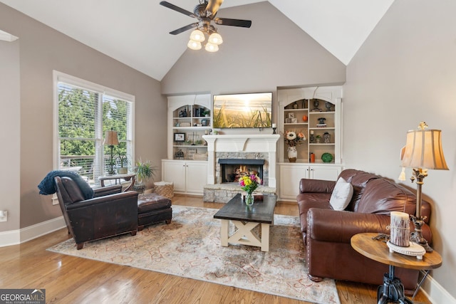 968 Woodtrace Ln, Auburn, GA 30011 - living area with baseboards, a stone fireplace, a ceiling fan, wood finished floors, and high vaulted ceiling