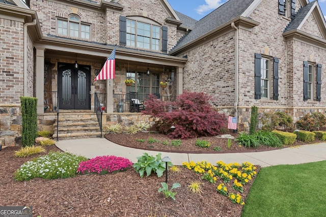 968 Woodtrace Ln, Auburn, GA 30011 - view of exterior entry featuring brick siding, french doors, and a shingled roof