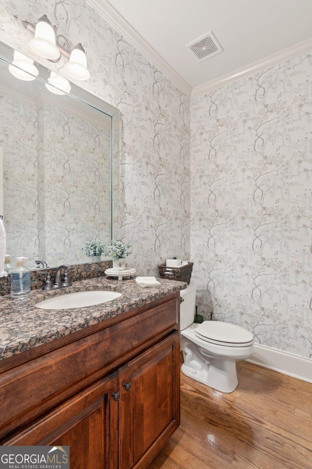 968 Woodtrace Ln, Auburn, GA 30011 - bathroom featuring vanity, crown molding, toilet, visible vents, and wood finished floors