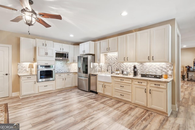 968 Woodtrace Ln, Auburn, GA 30011 - kitchen with appliances with stainless steel finishes, light wood-type flooring, backsplash, ceiling fan, and a sink