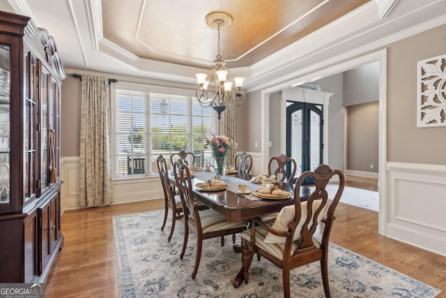 968 Woodtrace Ln, Auburn, GA 30011 - dining area with crown molding, a chandelier, a raised ceiling, french doors, and light wood finished floors