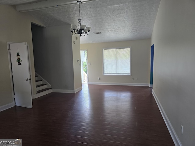 unfurnished living room with a notable chandelier, dark wood-type flooring, beamed ceiling, visible vents, and stairway