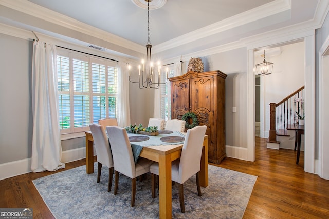 dining area with visible vents, ornamental molding, wood finished floors, and a chandelier