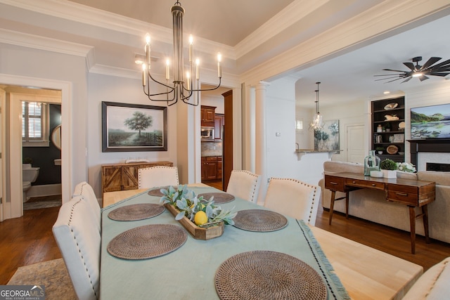 dining room featuring decorative columns, an inviting chandelier, ornamental molding, built in shelves, and wood finished floors
