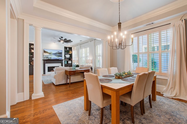 dining room featuring visible vents, ornamental molding, wood finished floors, built in shelves, and a notable chandelier