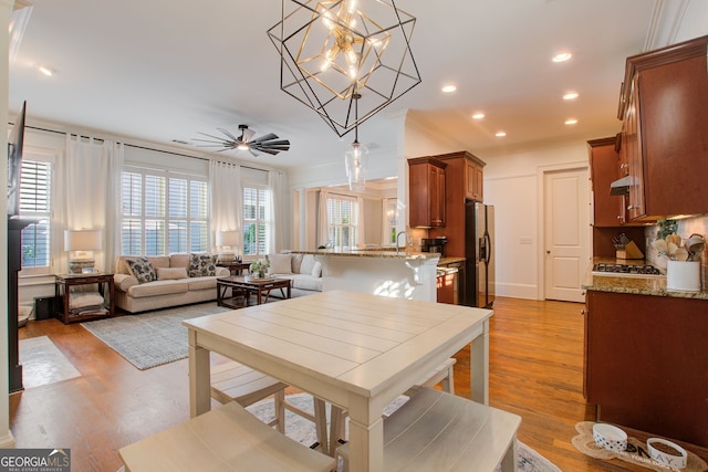 dining room featuring light wood-style floors, recessed lighting, and ceiling fan with notable chandelier