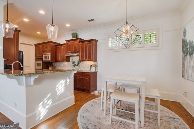 kitchen with dark wood-type flooring, white microwave, stone countertops, and oven