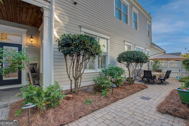 view of side of property featuring a patio and fence