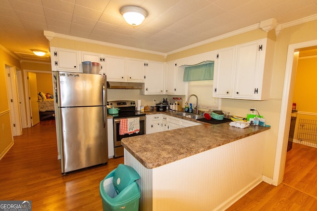 209 Elm St, Brooklet, GA 30415 - kitchen with wood finished floors, appliances with stainless steel finishes, under cabinet range hood, white cabinetry, and a sink