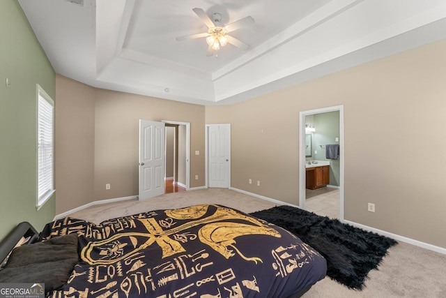 79 Tiffany Trce, Palmetto, GA 30268 - bedroom featuring a ceiling fan, a raised ceiling, ensuite bathroom, baseboards, and light colored carpet