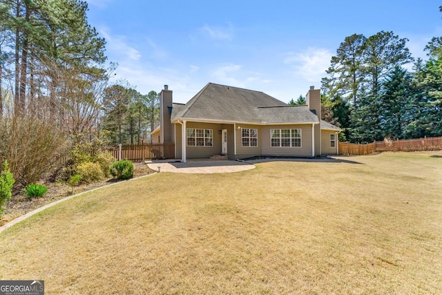 79 Tiffany Trce, Palmetto, GA 30268 - back of property with a patio area, a lawn, fence, and a chimney