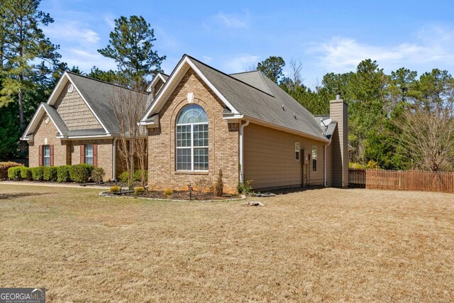 79 Tiffany Trce, Palmetto, GA 30268 - view of front of property featuring roof with shingles, brick siding, fence, and a front lawn