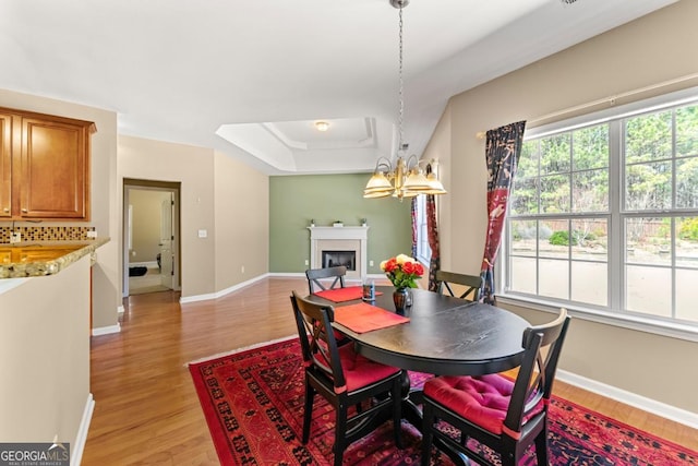 79 Tiffany Trce, Palmetto, GA 30268 - dining area featuring baseboards, a fireplace, light wood-style flooring, and a notable chandelier