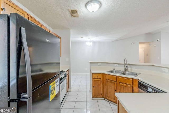870 Chapman Cir, Stone Mountain, GA 30088 - kitchen featuring freestanding refrigerator, gas range, a textured ceiling, light tile patterned flooring, and light countertops