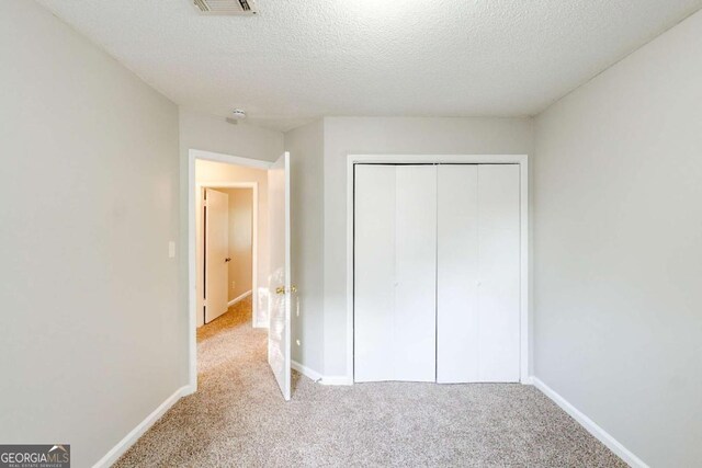 870 Chapman Cir, Stone Mountain, GA 30088 - unfurnished bedroom featuring carpet, a textured ceiling, and a closet