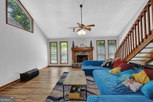 living area with plenty of natural light, a textured ceiling, baseboards, and wood finished floors