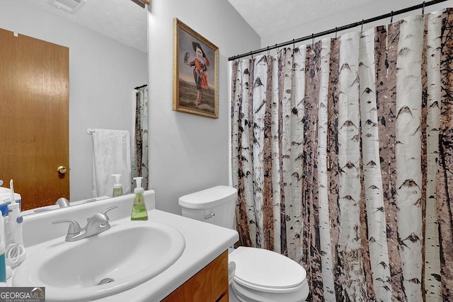 full bathroom with a textured ceiling, visible vents, toilet, and vanity