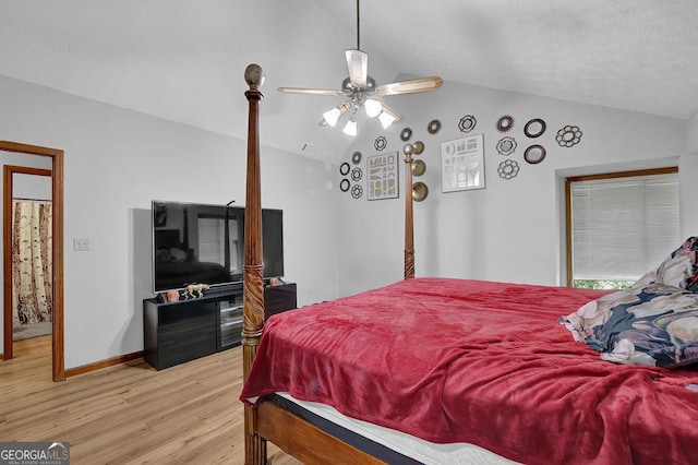 bedroom featuring light wood finished floors, vaulted ceiling, baseboards, and a ceiling fan