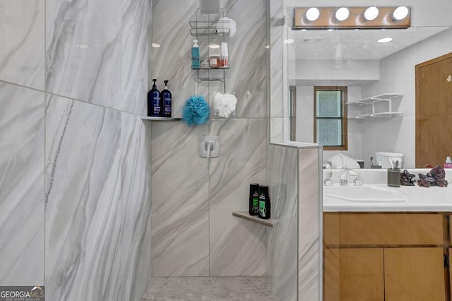 bathroom with walk in shower, toilet, and vanity