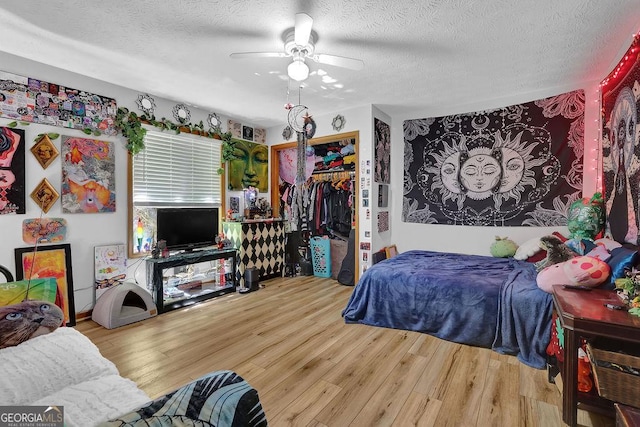 bedroom featuring wood finished floors, a textured ceiling, and a closet