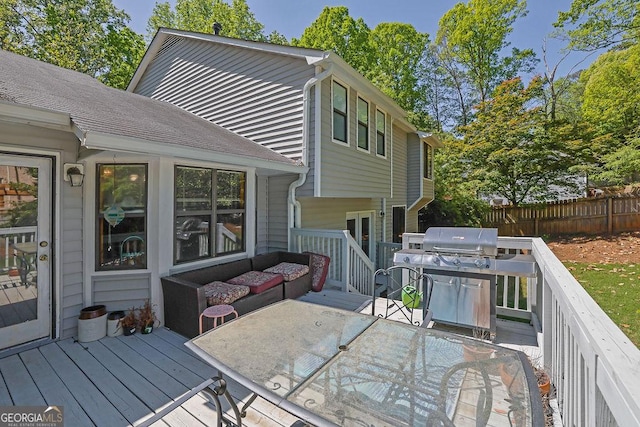 wooden terrace with fence, a grill, and outdoor dining space