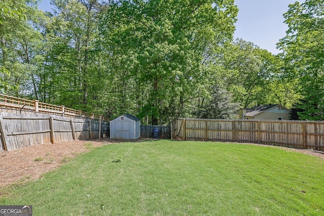 view of yard with a fenced backyard, an outbuilding, and a shed