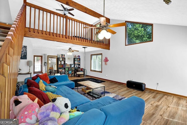 living room featuring wood finished floors, a healthy amount of sunlight, and ceiling fan