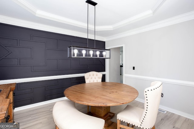 4215 Steeplehill Dr NW, Kennesaw, GA 30144 - dining space with light wood-style floors, a raised ceiling, and crown molding