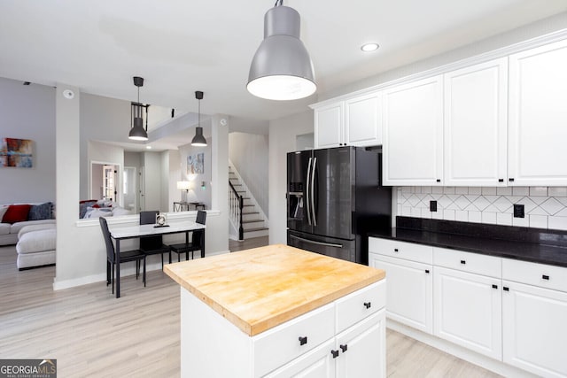 4215 Steeplehill Dr NW, Kennesaw, GA 30144 - kitchen featuring black fridge, light wood finished floors, decorative backsplash, open floor plan, and white cabinetry