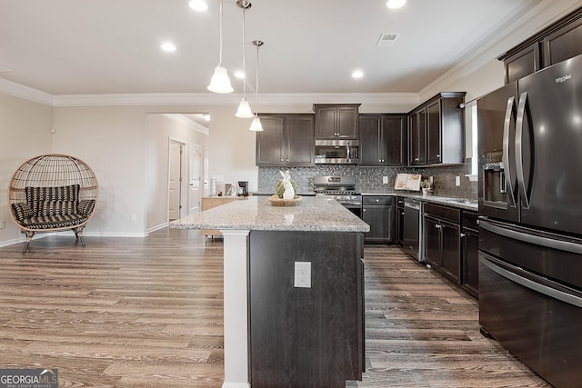 32 October Ave, Newnan, GA 30265 - kitchen featuring appliances with stainless steel finishes, a center island, ornamental molding, dark wood-style floors, and light stone countertops