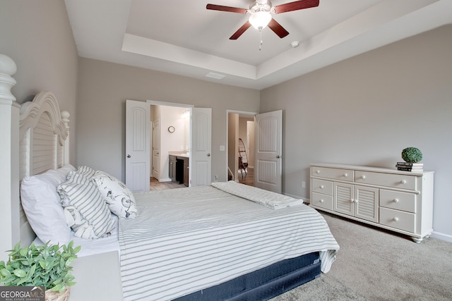 32 October Ave, Newnan, GA 30265 - bedroom featuring light colored carpet, a tray ceiling, connected bathroom, baseboards, and a ceiling fan