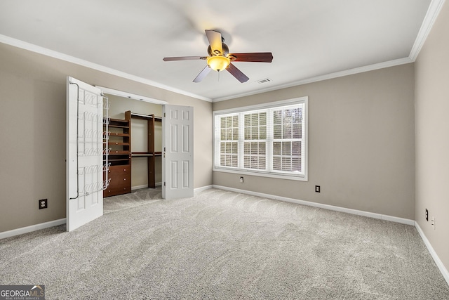 unfurnished bedroom with baseboards, visible vents, crown molding, and carpet