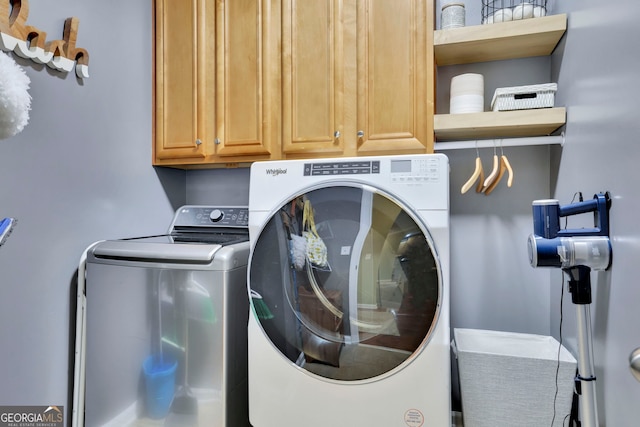 clothes washing area with cabinet space and independent washer and dryer