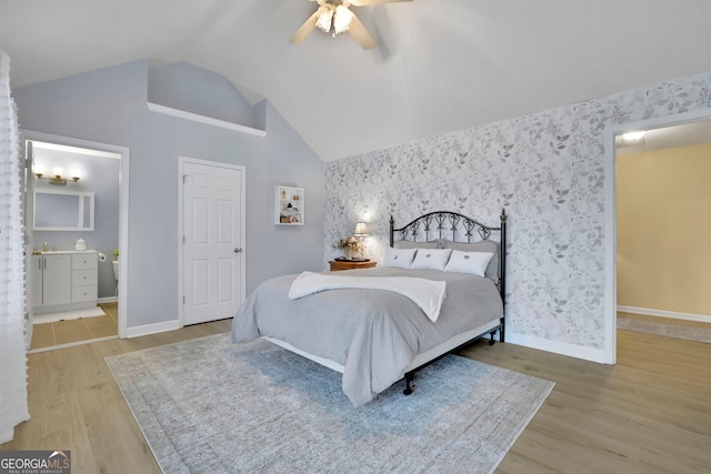 bedroom with baseboards, wallpapered walls, and wood finished floors