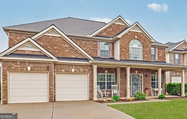view of front of home with a shingled roof, covered porch, a garage, concrete driveway, and brick siding