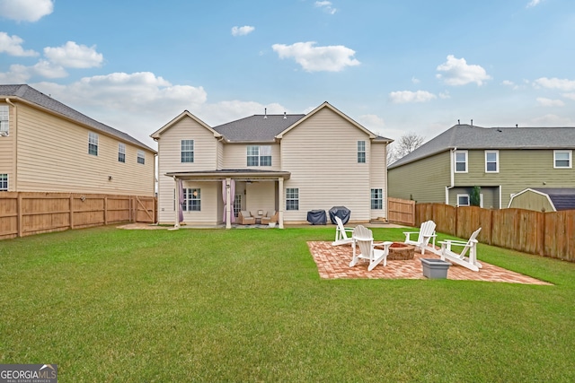back of house with a yard, an outdoor fire pit, a fenced backyard, and a patio